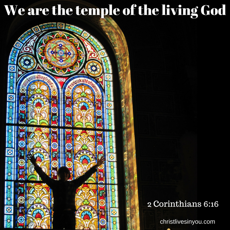 A man stands in front of a stained glass window inside a church or temple