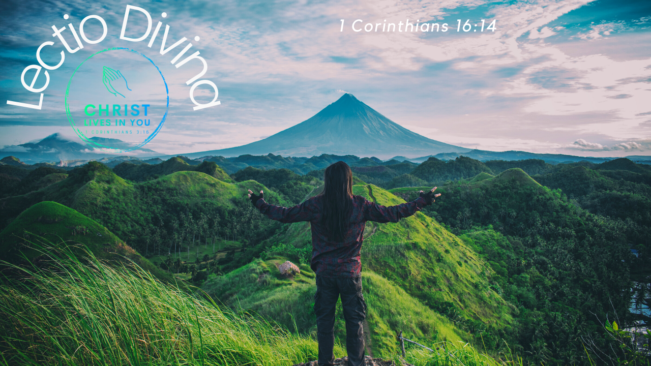 A person with outstretched arms looking out over beautiful green mountains